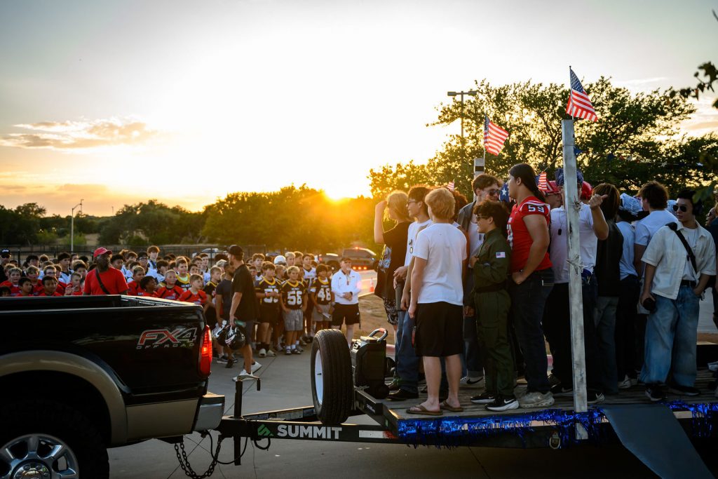 Henry Hawks football players lined up with the youth teams before the Vista Ridge homecoming parade