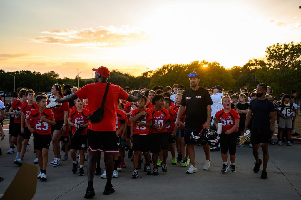 Henry Hawks football players lined up with the youth teams before the Vista Ridge homecoming parade