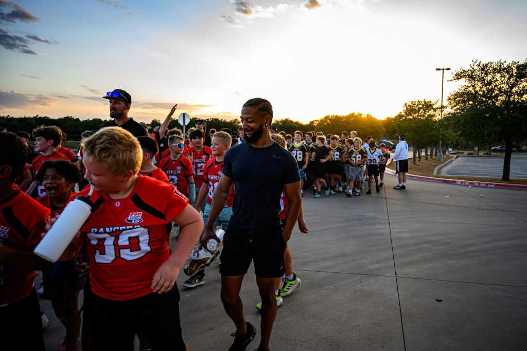 Henry Hawks football players lined up with the youth teams before the Vista Ridge homecoming parade