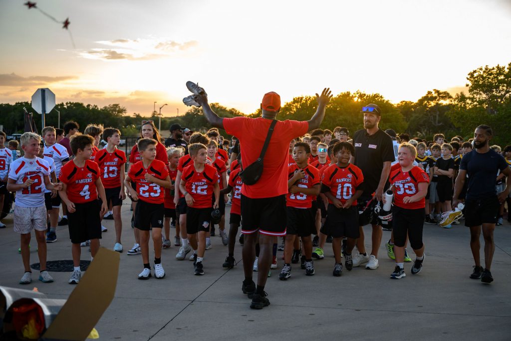 Henry Hawks football players lined up with the youth teams before the Vista Ridge homecoming parade